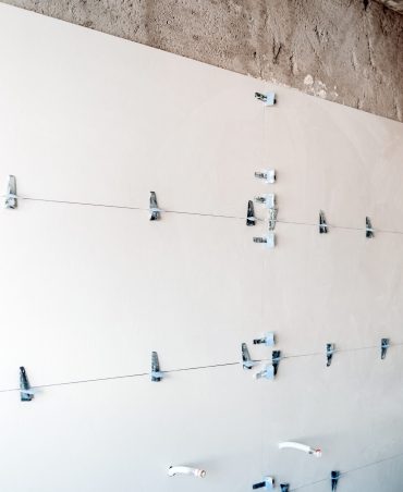 construction site. white modern tiles on bathroom with separator and leveling during works. Home renovation